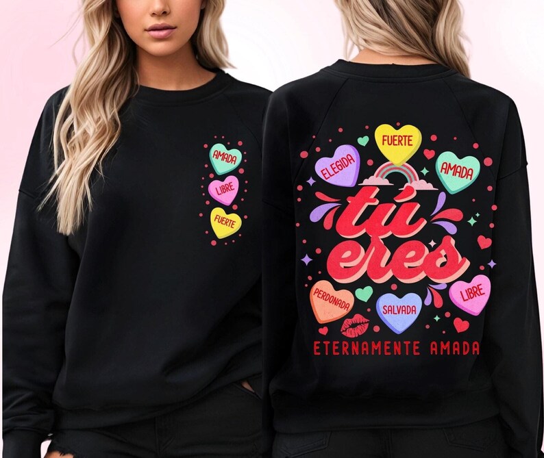 May include: Black sweatshirt with a rainbow and the text "tu eres" in red and white. The sweatshirt has several hearts with Spanish words on them, including "amada", "libre", "fuerte", "elegida", "perdonada", "salvada", and "eternamente amada".