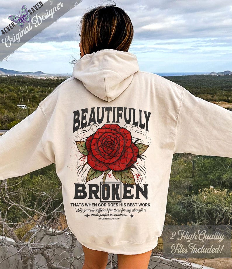 May include: Cream-colored hoodie with a large red rose graphic and the words "BEAUTIFULLY BROKEN." The back of the hoodie also features the text "THATS WHEN GOD DOES HIS BEST WORK" and "My grace is sufficient for thee: for my strength is made perfect in weakness."