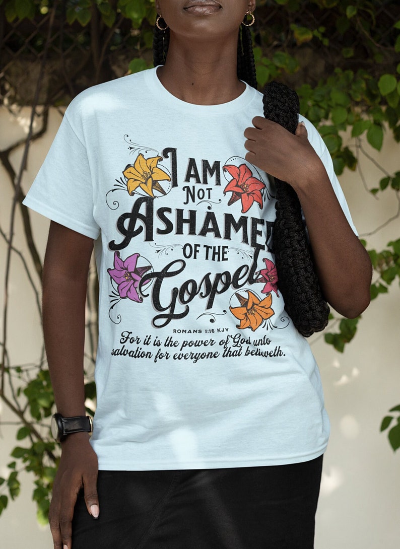May include: Light blue t-shirt with a floral design and the text "I am not ashamed of the Gospel" with a Bible verse from Romans 1:16 KJV.