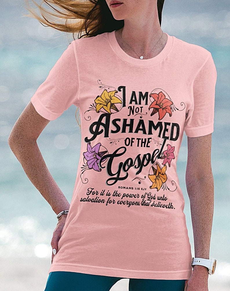 May include: Pink t-shirt with a floral design and the text "I am not ashamed of the Gospel" with a Bible verse from Romans 1:16 KJV.