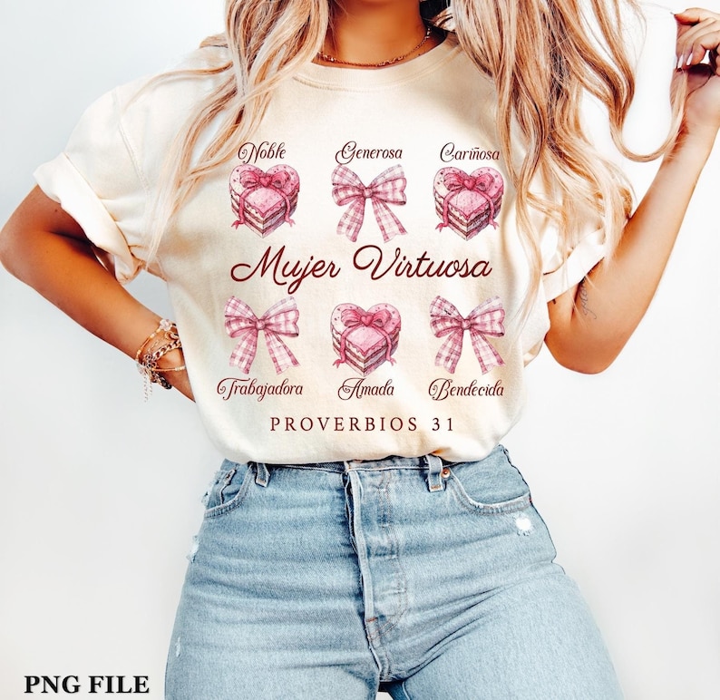 May include: A white t-shirt with a pink and brown design featuring a heart-shaped cake with the words "Mujer Virtuosa" and "Proverbios 31" in brown text. The design also includes the words "Noble", "Generosa", "Cari&ntilde;osa", "Trabajadora", "Amada", and "Bendecida" in pink text.