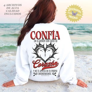 May include: White sweatshirt with the word "CONF&Iacute;A" in red, above a black and gray heart design. Below, the word "Coraz&oacute;n" is in red script. Text in Spanish reads "Y NO TE APOYES EN TU PROPIO ENTENDIMIENTO. PROVERBIOS 3:5."
