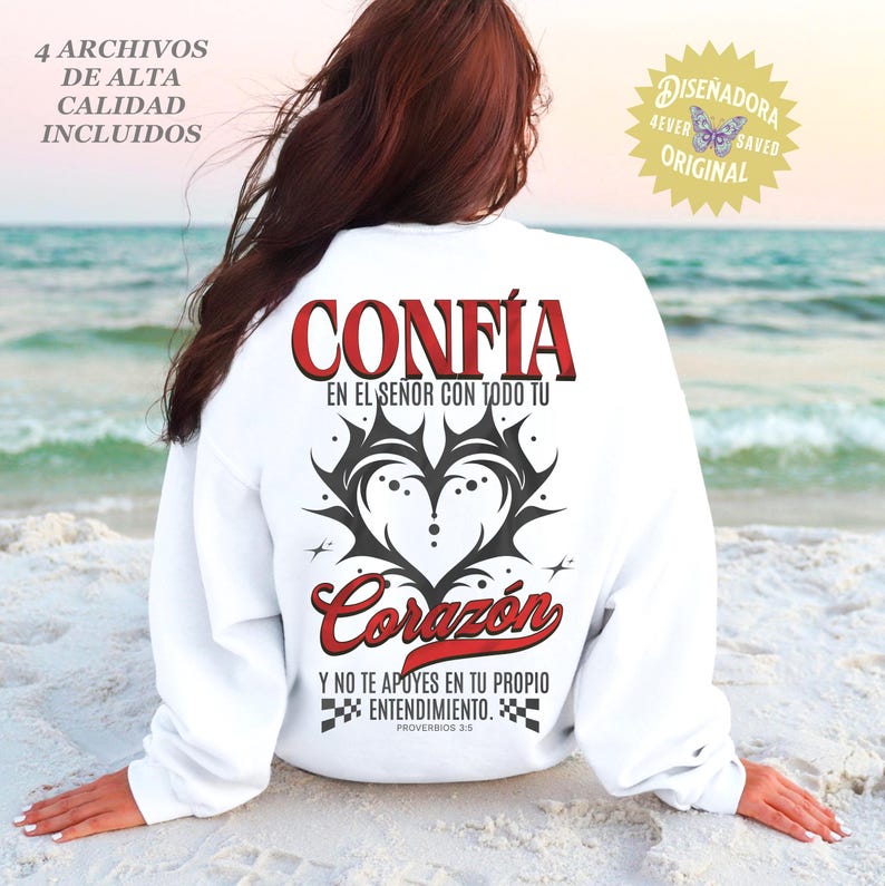 May include: White sweatshirt with the word "CONF&Iacute;A" in red, above a black and gray heart design. Below, the word "Coraz&oacute;n" is in red script. Text in Spanish reads "Y NO TE APOYES EN TU PROPIO ENTENDIMIENTO. PROVERBIOS 3:5."