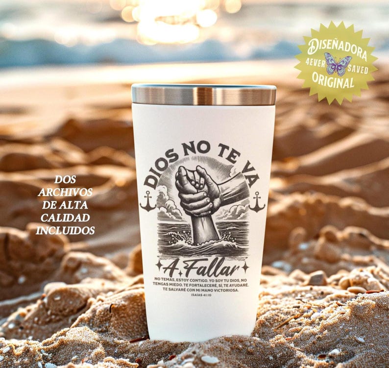 May include: A white travel tumbler with a silver rim, featuring a black and white illustration of a hand emerging from water, with the words "DIOS NO TE VA A Fallar" and other text. The tumbler is on a sandy beach.