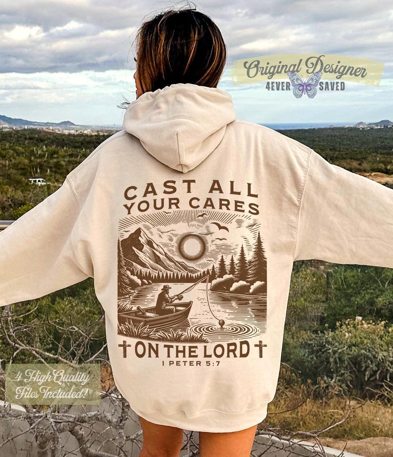 May include: Cream-colored hoodie with a graphic on the back featuring a lake scene with a person fishing, mountains, and the text "CAST ALL YOUR CARES ON THE LORD". The hoodie also has the text "Original Designer 4ever Saved".