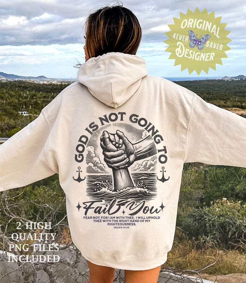 Op de afbeelding: Een cr&egrave;mekleurige hoodie met een grafische print op de rug die zegt "God zal je niet in de steek laten." De afbeelding toont een hand die uit het water reikt en door een andere hand wordt gegrepen. De tekst "Vrees niet, want Ik ben met u, Ik zal u met de rechterhand van mijn gerechtigheid ondersteunen. Jesaja 41:10" staat onder de afbeelding gedrukt.