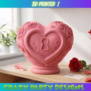Puede incluir: Objeto decorativo rosa en forma de corazón, impreso en 3D, con diseño de cerradura y detalles de rosas. El texto "3D PRINTED!" está en la parte superior y "CRAZY PARTY DESIGNS" en la inferior.