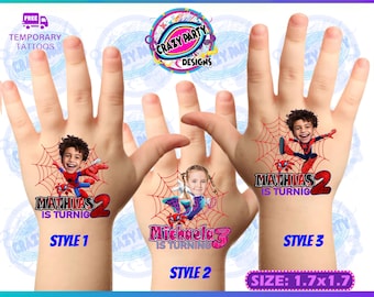 May include: Three temporary tattoo designs featuring a Spiderman character with a child's face superimposed on the character's head. The tattoos are printed on a white background and are approximately 4.3 cm by 4.3 cm. The text on the tattoos reads "Mathias is turning 2", "Michaela is turning 3", and "Mathias is turning 2".
