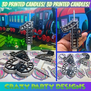 Puede incluir: Velas impresas en 3D con forma de número uno, con un diseño de vía de tren. Las velas son plateadas y negras, y se muestran sobre un fondo blanco. La imagen también muestra un tren de juguete y un primer plano de las velas.