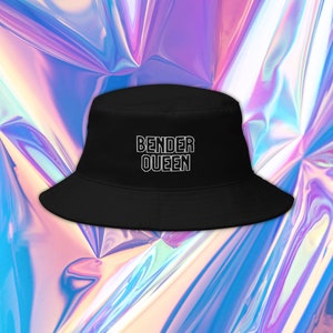 Op de afbeelding: Zwarte bucket hat met witte tekst die "Bender Queen" zegt.