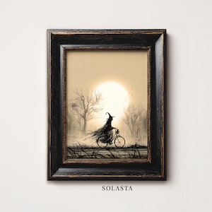 May include: A framed art print featuring a black ink illustration of a figure in a pointed hat and flowing cloak riding a bicycle through a misty landscape with bare trees and a large, pale sun. The word SOLASTA is printed below the frame.