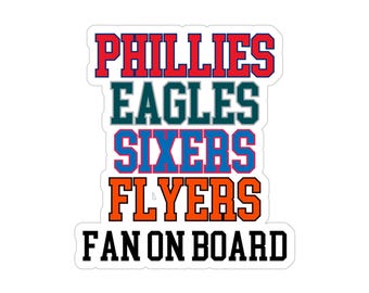 以下が含まれることがあります： 赤、緑、青、オレンジのブロック体で「PHILLIES EAGLES SIXERS FLYERS FAN ON BOARD」と書かれた白いステッカー。フィラデルフィアのスポーツチームのファン向けです。