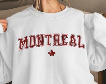 May include: White sweatshirt with a red "MONTREAL" graphic and a red maple leaf.