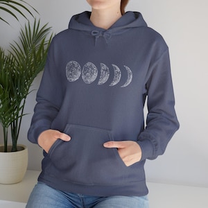 May include: A navy blue hooded sweatshirt with a white graphic of the moon in different phases.