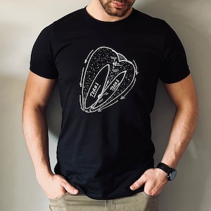 May include: A black t-shirt featuring a white graphic of a torus, a geometric shape with a hole in the middle. The graphic includes the word "Torus" written twice.