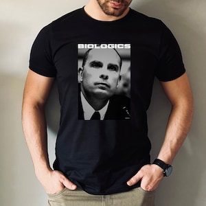 May include: A black t-shirt with a white graphic print of a man's face and the word "BIOLOGICS" above it.