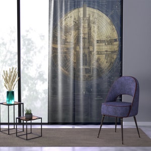 May include: A blue velvet chair with gold trim and black legs sits in front of a curtain featuring a vintage blueprint design. The blueprint depicts a circular design with intricate details.