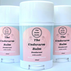 May include: Three white deodorant sticks with pink and blue labels. The label reads "The Underarm Balm Deodorant with zeolite Orange & Cardamom 50ml".