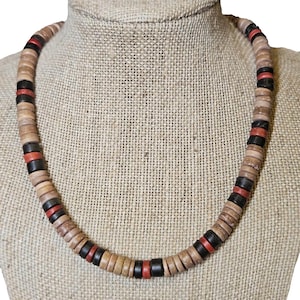 May include: A wooden beaded necklace with brown, black, and red beads. The necklace is on a fabric-covered mannequin.