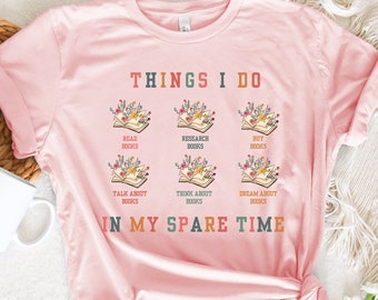 May include: Pink t-shirt with the text "THINGS I DO" and a graphic of six open books with flowers on them. The text below the books reads "IN MY SPARE TIME".