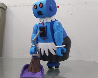 Puede incluir: Una figura de robot de limpieza azul y blanco que sostiene una pala de polvo púrpura y una escoba marrón. El robot tiene ojos rojos y un cuello blanco con volantes.