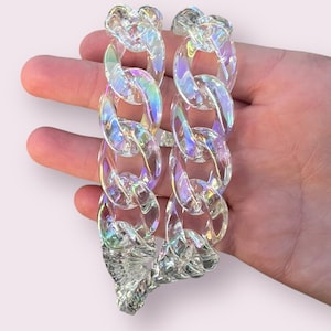 May include: A clear iridescent plastic chain necklace with large links.
