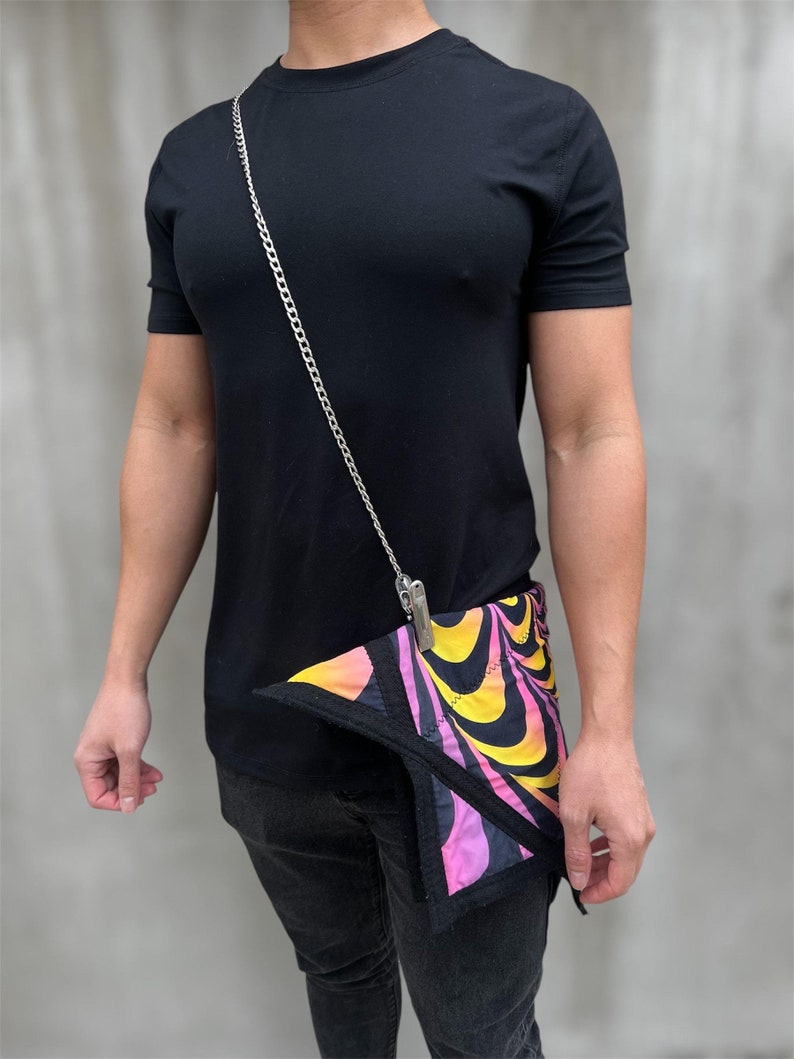 May include: A black t-shirt with a silver chain and a colorful patterned bandana attached to the chain.