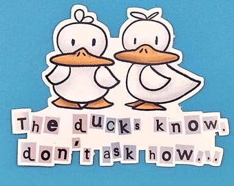 May include: A sticker featuring two cartoon ducks with white bodies, orange beaks and feet, and black eyes. The text "The ducks know. don't ask how.." is below the ducks, cut from various letters.