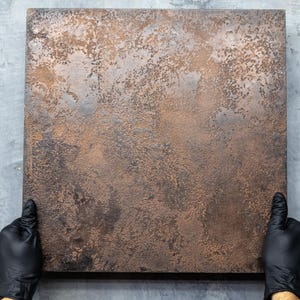 May include: A close-up of a textured, metallic surface with a rusty brown and copper colour. The surface is smooth and has a subtle sheen.