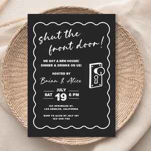 Puede incluir: Tarjeta de invitaci&oacute;n negra con texto blanco, incluyendo "shut the front door!" y detalles del evento. La tarjeta est&aacute; enmarcada con un borde blanco ondulado y presenta un gr&aacute;fico de pomo de puerta. La invitaci&oacute;n est&aacute; sobre una cesta tejida.
