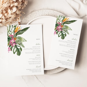 Może przedstawiać: Dwie białe karty menu z kwiatowymi wzorami akwarelowymi. Karty przedstawiają tropikalne kwiaty, w tym rajskie ptaki, orchidee i liście monstery. Tekst menu jest prostą, elegancką czcionką.
