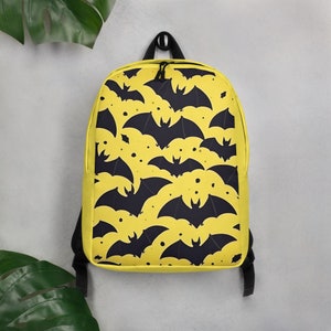 Aventuras ensolaradas aguardam: mochila infantil amarela com design divertido de morcego!