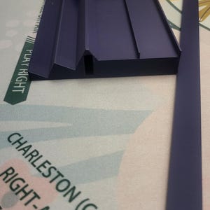 K&ouml;nnte beinhalten: Ein marineblauer Mahjong-Kartenhalter mit wei&szlig;en und blauen Karten. Die Karten haben rote und schwarze Markierungen. Das Spielbrett tr&auml;gt die Aufschrift "PLAY RIGHT" und "CHARLESTON (COMPULS".