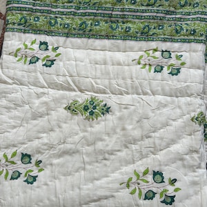 May include: White cotton quilt with a green floral pattern. The quilt has a border of green floral designs.