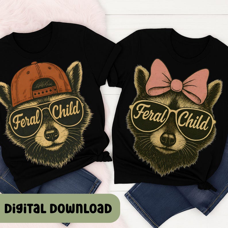以下が含まれることがあります： 「Feral Child」と書かれたサングラスをかけたアライグマのグラフィックがプリントされた2枚の黒いTシャツ。1匹のアライグマは茶色のキャップをかぶり、もう1匹はピンクのリボンをしています。「Digital Download」というフレーズが下にあります。