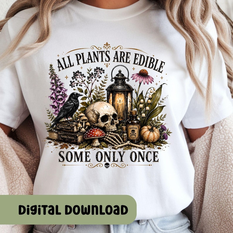 Puede incluir: Una camiseta blanca con un estampado gr&aacute;fico de una calavera, un cuervo negro, un farol, una botella peque&ntilde;a con la etiqueta poison, una calabaza y varias plantas. El texto dice ALL PLANTS ARE EDIBLE SOME ONLY ONCE, con libros titulados Herbal Guide y Garden Secrets.