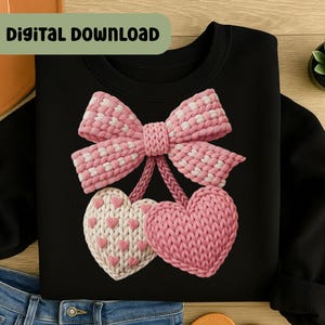May include: Black sweatshirt featuring a pink and white bow design above two knitted hearts. The hearts are pink and white, with a small heart pattern on one. The words "DIGITAL DOWNLOAD" are in a green rectangle at the top.
