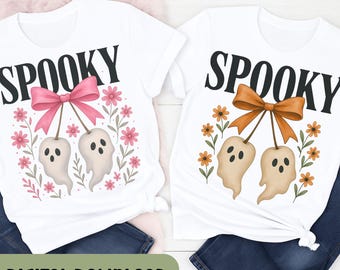 Puede incluir: Dos camisetas blancas con la palabra "SPOOKY" en letras negras. Cada camiseta presenta un gráfico de dos figuras fantasmales colgando de un lazo, rodeadas de flores. Un lazo es rosa, el otro naranja. El texto "DIGITAL DOWNLOAD" está en la parte inferior.