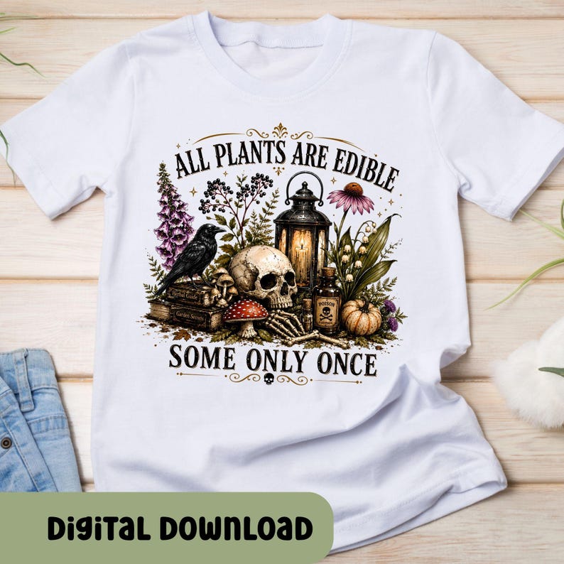 Puede incluir: Una camiseta blanca con un estampado gr&aacute;fico de una calavera, un cuervo negro, un farol, una botella peque&ntilde;a, setas y varias plantas. El texto dice ALL PLANTS ARE EDIBLE SOME ONLY ONCE e incluye una ilustraci&oacute;n de una mano esquel&eacute;tica.