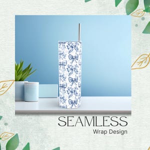 May include: A tall, stainless steel tumbler with a blue and white floral and bow pattern. The tumbler has a silver straw and the words "SEAMLESS Wrap Design" at the bottom. The tumbler is on a white surface with a blue background.