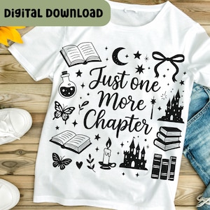 以下が含まれることがあります： 「Just one More Chapter」の文字と本、城、蝶、星のイラストが描かれた黒いグラフィックデザインの白いTシャツ。「Digital Download」の文字が緑色のボックスに入っています。