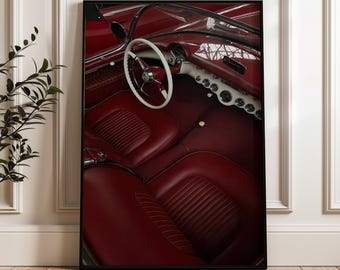 Puede incluir: Una impresión de arte mural enmarcada que muestra el interior de un coche descapotable rojo de época. La imagen presenta asientos de cubo de cuero rojo oscuro, un volante blanco, un salpicadero con indicadores circulares y un parabrisas.