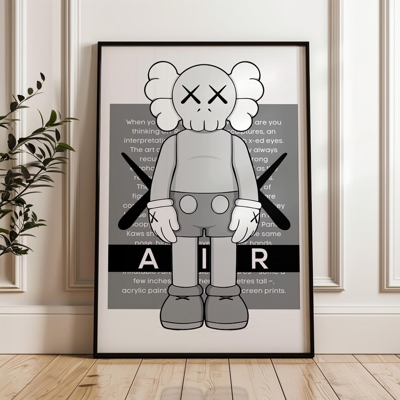 Puede incluir: Un estampado enmarcado que presenta una figura de dibujos animados gris con ojos tachados y guantes. La figura est&aacute; frente a un fondo gris con texto y la palabra "AIR". La obra de arte est&aacute; en un marco negro. Aproximadamente 60 cm de altura.