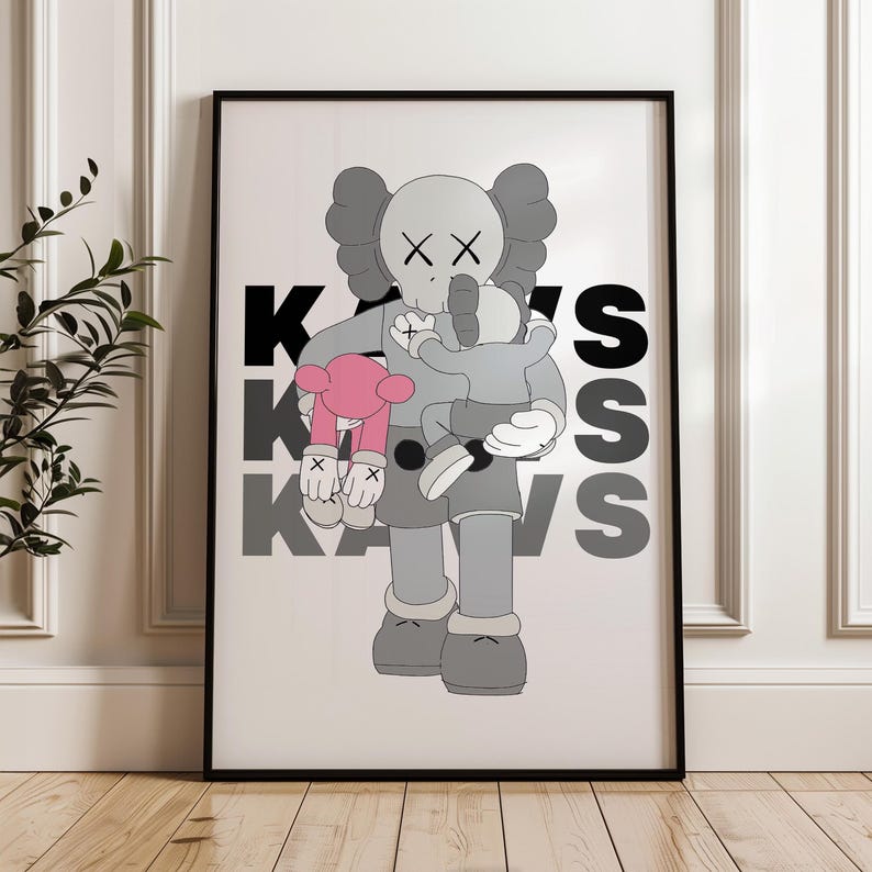 Puede incluir: Impresi&oacute;n art&iacute;stica enmarcada que presenta una figura de dibujos animados abrazando a otra figura y un peluche rosa. Las figuras son grises con detalles negros y la palabra "Kaws" est&aacute; impresa en negro y gris. La obra de arte se presenta en un marco negro.