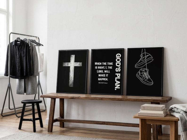 May include: Three framed black and white art prints with religious themes. One features a cross, another has text that reads "When the time is right, I, the Lord, will make it happen," and the third shows sneakers. The prints are displayed on a wooden bench.