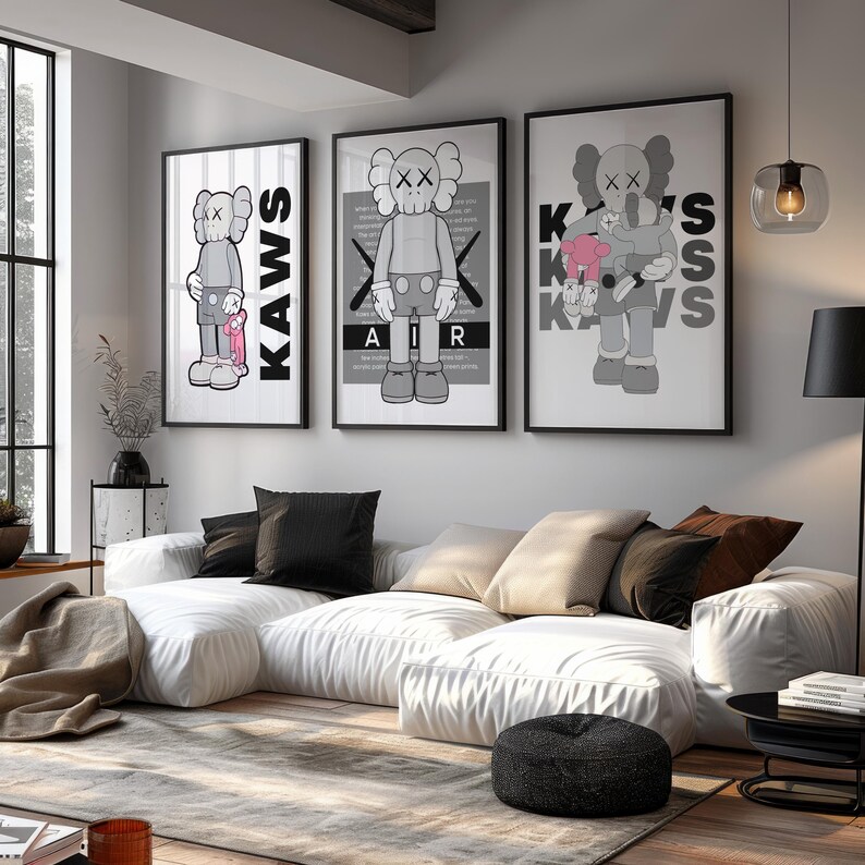 Puede incluir: Tres impresiones art&iacute;sticas enmarcadas de KAWS. Las impresiones presentan el personaje caracter&iacute;stico de KAWS en varias poses, con una combinaci&oacute;n de colores gris y blanco. La obra de arte se exhibe sobre un sof&aacute; seccional blanco con cojines negros y beige. Un otom&aacute;n negro y una alfombra estampada completan el sal&oacute;n.