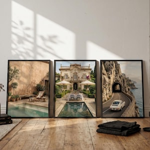 May include: Three framed wall art prints displayed side-by-side. The left print shows a pool patio with lounge chairs. The center print depicts a grand villa with a pool and dining area. The right print features a vintage car on a coastal road.