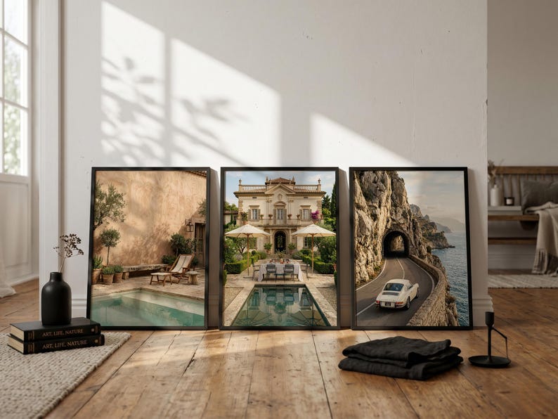 May include: Three framed wall art prints displayed side-by-side. The left print shows a pool patio with lounge chairs. The center print depicts a grand villa with a pool and dining area. The right print features a vintage car on a coastal road.