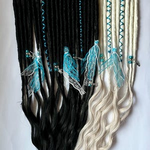 May include: Two sets of synthetic dreadlocks, one black and one blonde, with blue ribbon accents and lace charms.