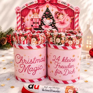 Könnte beinhalten: Ein rosa Adventskalender-Set mit zwei zylindrischen Behältern mit rot-weiß gestreiften Rändern. Der Hintergrund zeigt einen Nussknacker, eine Maus und eine Ballerina. Der Text lautet Christmas Magic und 24 kleine Freuden für Dich.